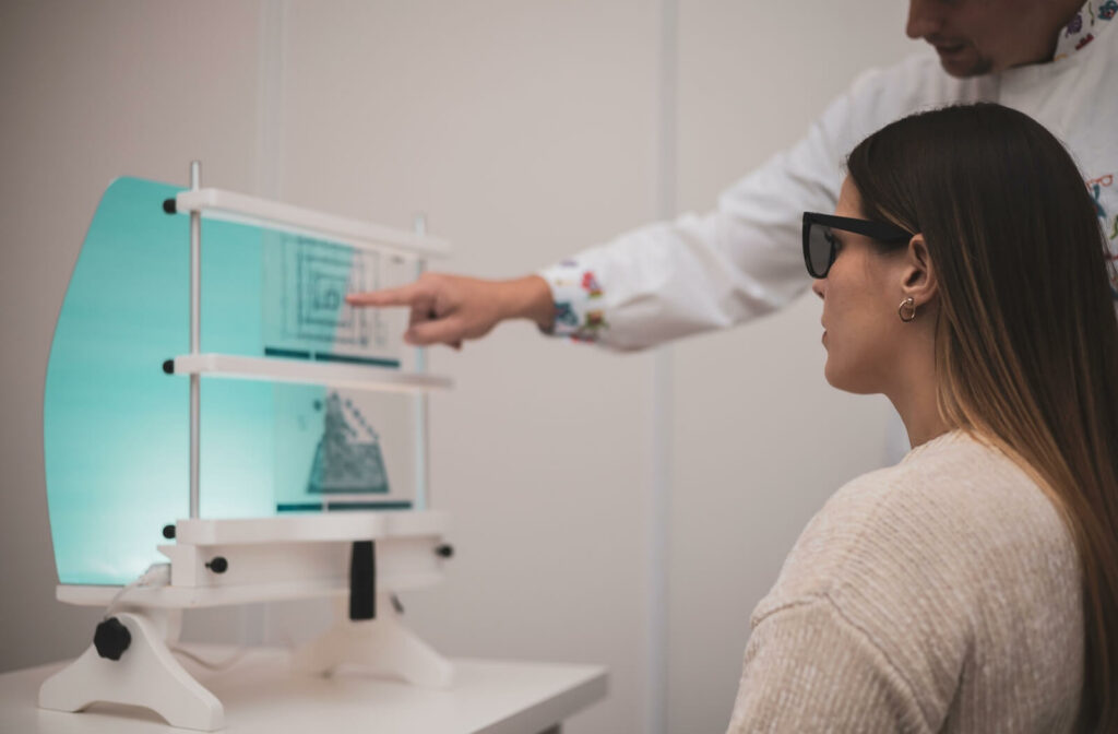 A young adult performs vision therapy eye exercises under the direction of their experienced eye doctor.