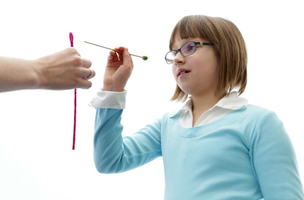 A child performs their eye exercises from their vision therapy plan at home with the help of their parent.