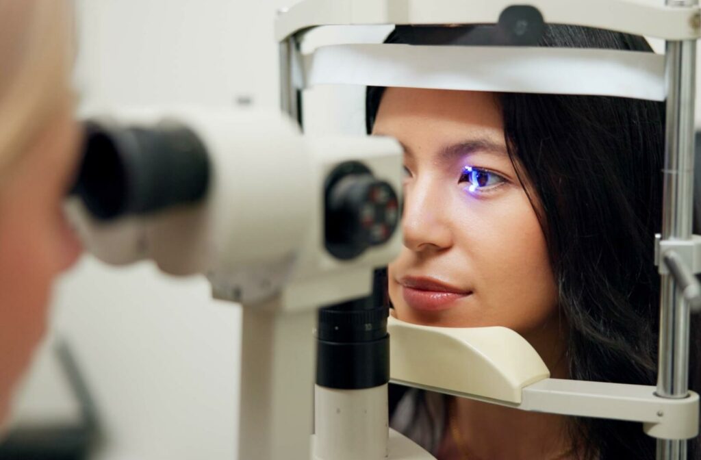 Patient undergoing an eye exam with a slit lamp microscope and blue light.
